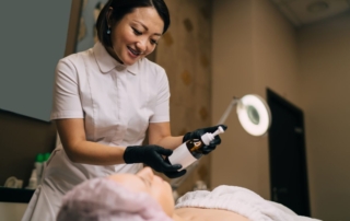 Specjalistka w dziedzinie dermatologii estetycznej przygotowuje zabieg dla klientki w gabinecie.