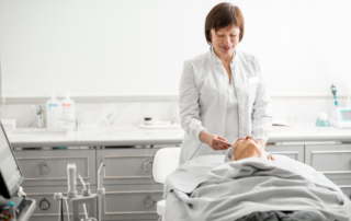 Kobieta w białym fartuchu wykonuje zabieg z zakresu medycyny estetycznej.