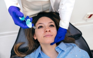 Kobieta poddaje się zabiegowi z zakresu dermatologii estetycznej.