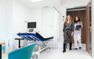 Pacjentka wchodzi do gabinetu w poradni urologicznej z uśmiechniętą lekarką.